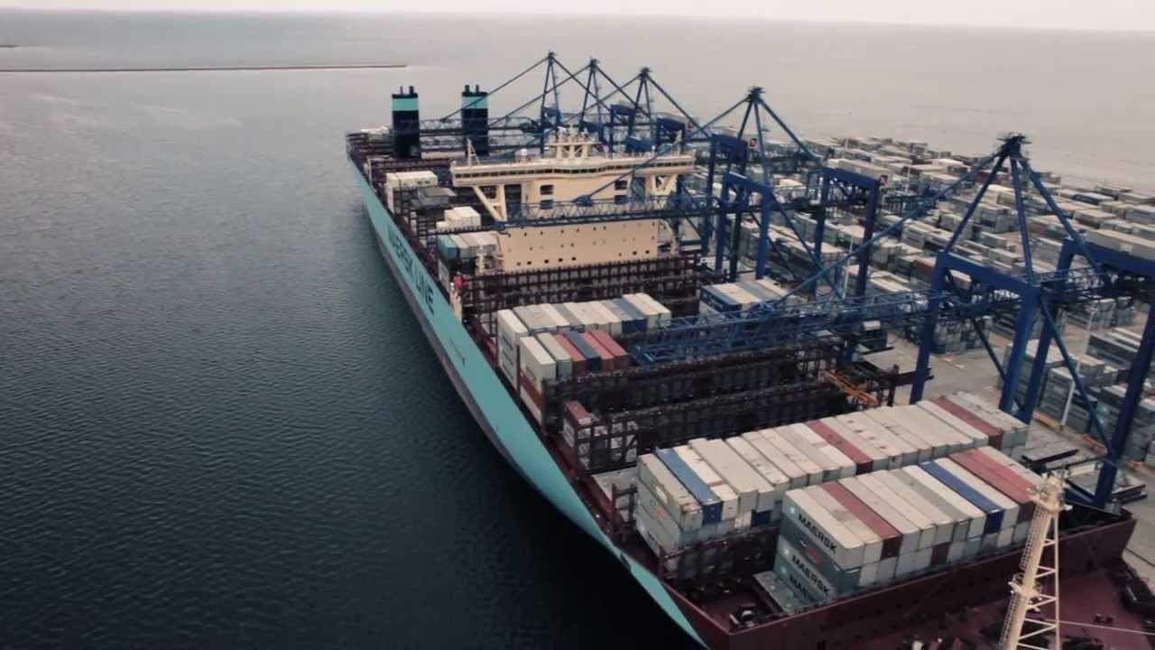 Kontenerowiec Maersk Line załadowany kontenerami, cumujący w porcie z dźwigami nabrzeżnymi, widok z lotu ptaka.