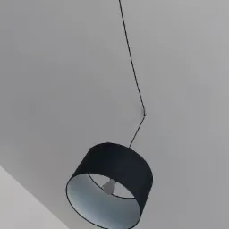 Czarna lampa wisząca z abażurem, zamontowana na białym suficie, widoczna żarówka wewnątrz abażuru.