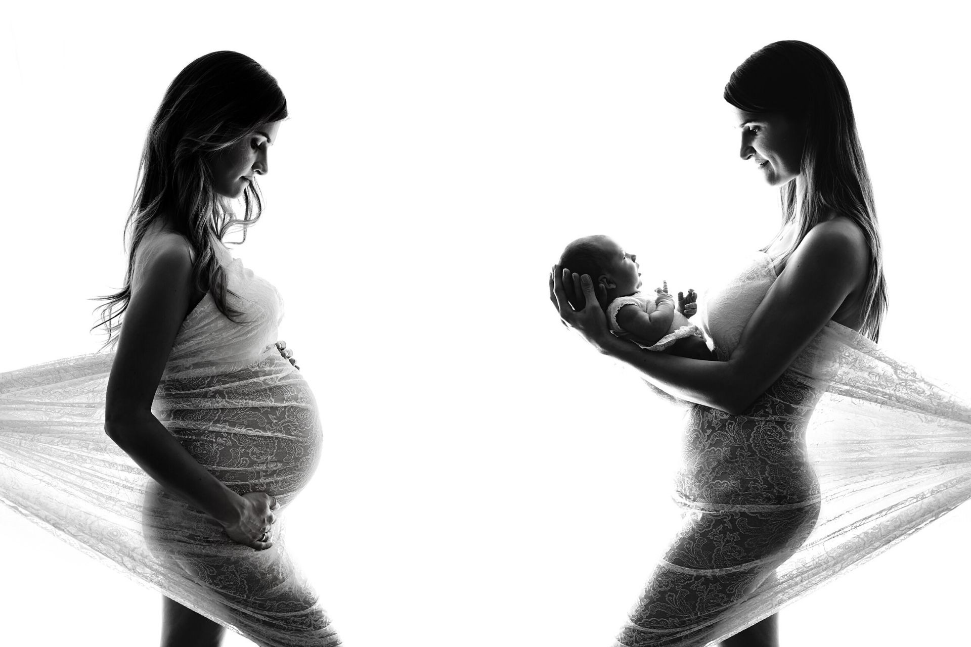 Czarno-białe zdjęcie przedstawia kobietę w ciąży i tę samą kobietę trzymającą noworodka, obie ubrane w koronkową sukienkę na jasnym tle.