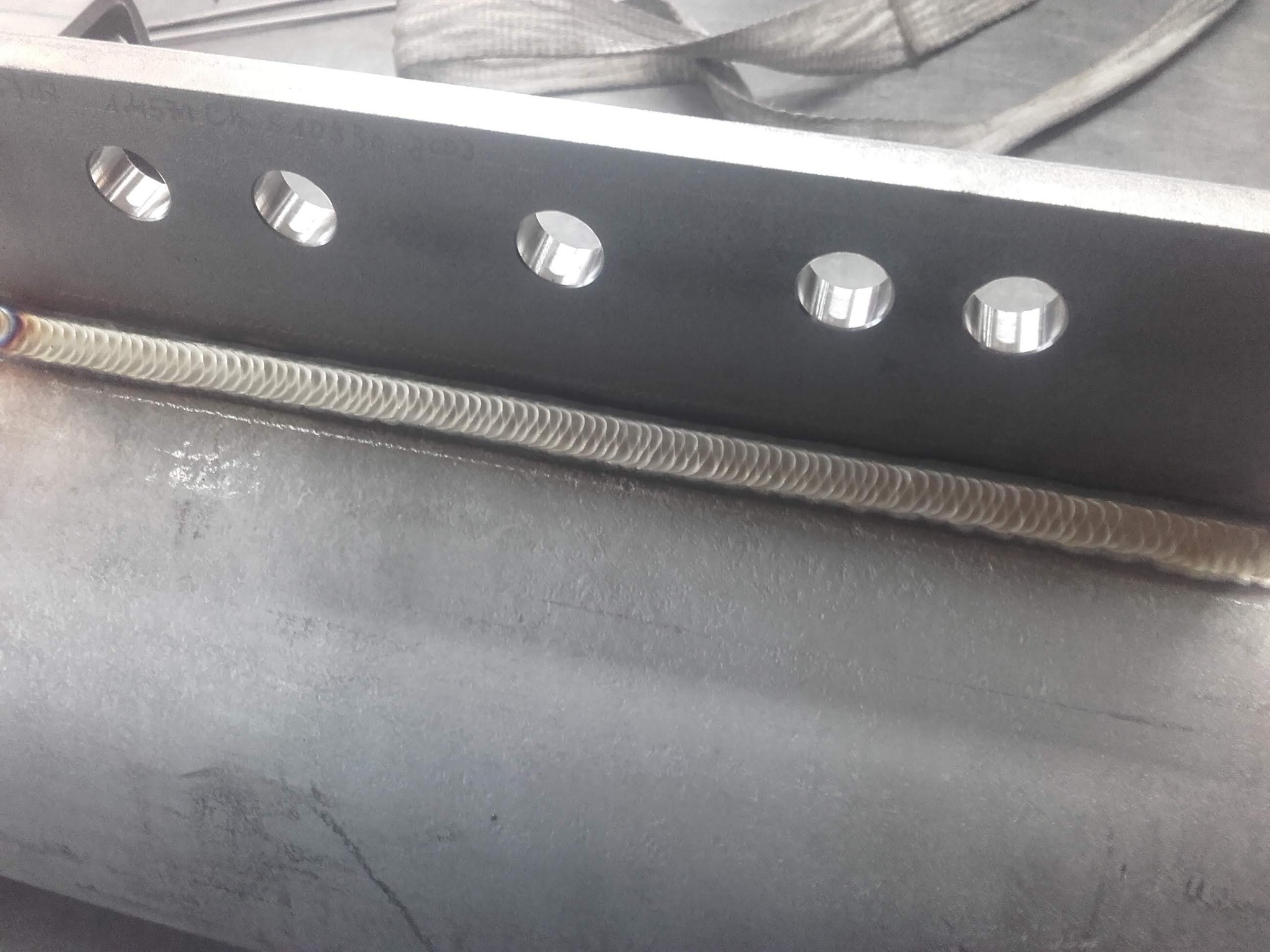 Metalowa konstrukcja z widocznym spoiną i rzędem otworów, ujęcie z bliska, podkreślające precyzję wykonania