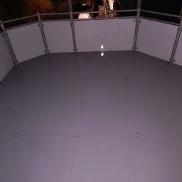 Sebastian Napierała - Świeżo wylana, błyszcząca posadzka żywiczna na balkonie z metalową balustradą, widok z góry w nocy.