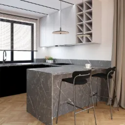 Nowoczesna kuchnia z wyspą wykończoną marmurem, dwie czarne hokery przy wyspie, białe szafki wiszące, drewniana podłoga w jodełkę, rolety w oknie.