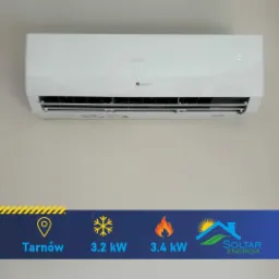 Biały klimatyzator GREE zamontowany na jasnej ścianie, z naklejką reklamową Soltar Energia wskazującą Tarnów, moc chłodniczą 3.2kW i grzewczą 3.4kW.