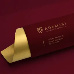 Elegancka wizytówka kancelarii adwokackiej Adamski w kolorze bordowym z elementami złota, prezentująca logo i dane kontaktowe