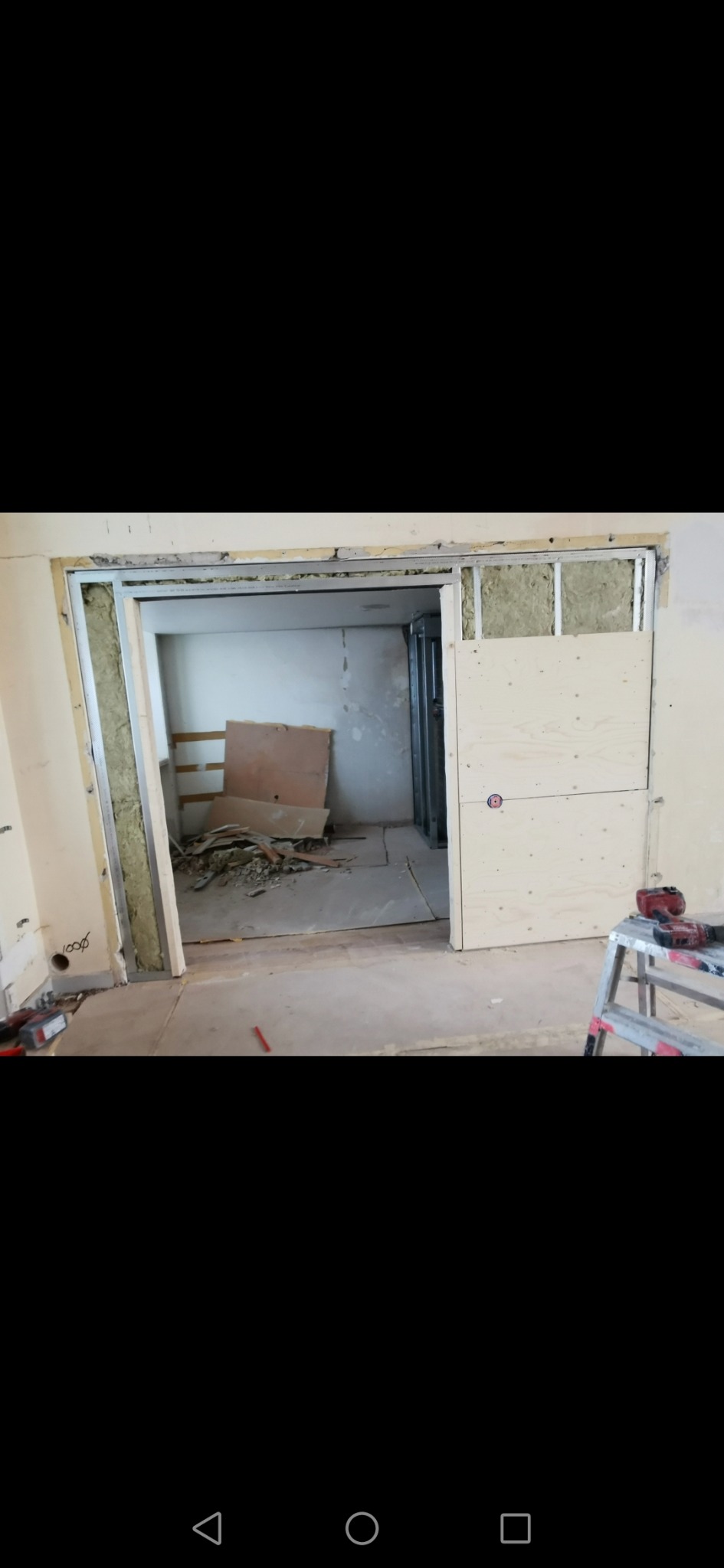 Montaż metalowej konstrukcji pod ścianę działową z izolacją wełną mineralną w Gdańsku, widoczne narzędzia i resztki materiałów budowlanych.