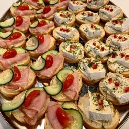przystanek Pierożkowo Gabriela Kupczyk - Elegancko ułożone na srebrnej tacy okrągłe kanapeczki: połowa z szynką, ogórkiem i pomidorkiem koktajlowym, druga połowa z serem brie, koperkiem i granatem.