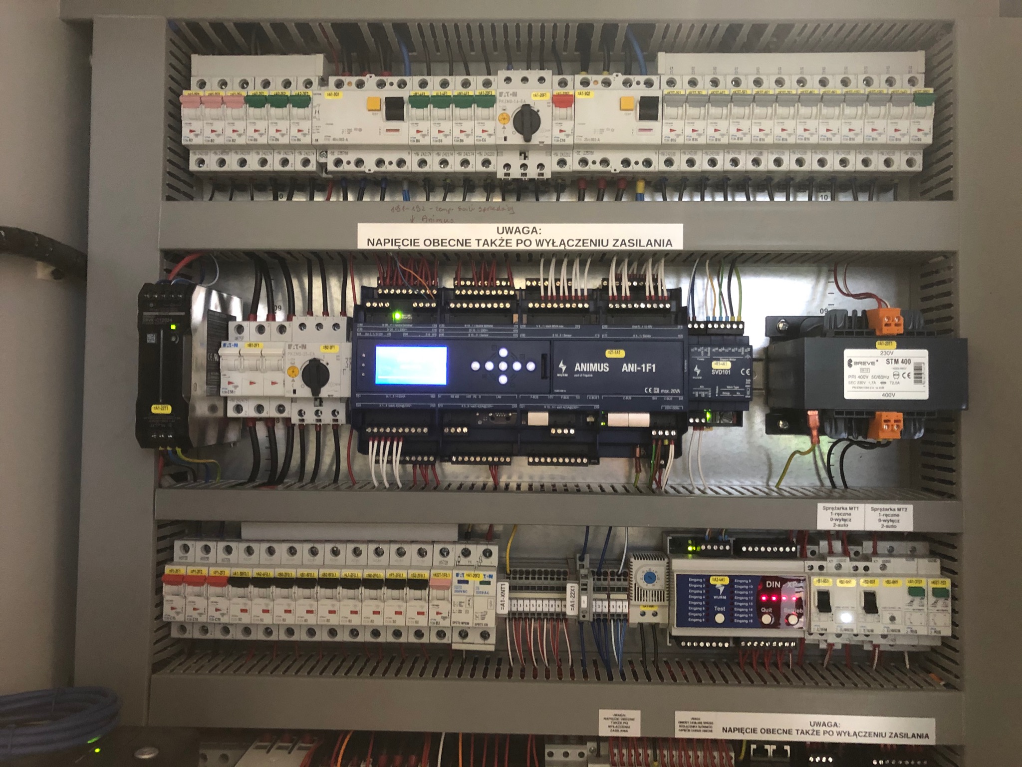 Rozbudowana szafa sterownicza z licznymi zabezpieczeniami, sterownikiem PLC Animus ANI-1F1 i modułami rozszerzeń, okablowanie uporządkowane w listwach.