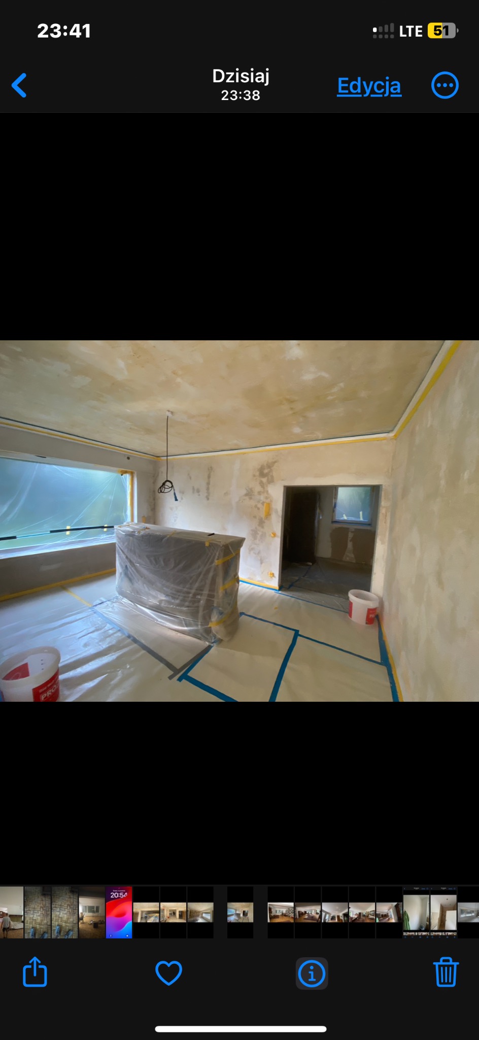 Pokój w trakcie przygotowań do malowania: zabezpieczona folią podłoga i meble, ściany po szpachlowaniu, taśma malarska przy suficie.