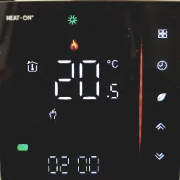Wyświetlacz panelu sterowania ogrzewaniem z temperaturą 20.5 stopni Celsjusza i ikonami tryb&oacute;w, w tym płomień, słońce, dom, zegar i liść.