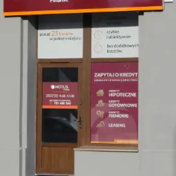 Wejście do placówki Notus Finanse, oferującej kredyty, ubezpieczenia i leasing, z informacją o godzinach otwarcia i numerem telefonu.