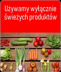 Świeże warzywa i owoce ułożone na drewnianym stole pod czerwonym napisem 'Używamy wyłącznie świeżych produktów'