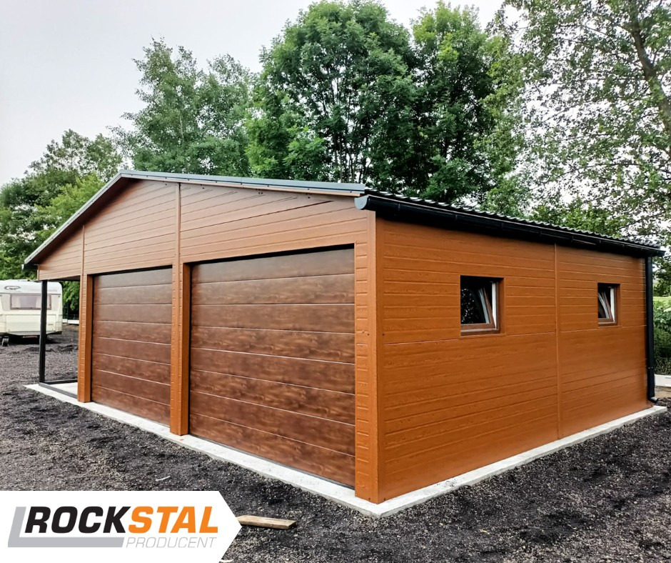 Gotowy dwustanowiskowy garaż blaszany z bramami segmentowymi o strukturze drewna, z oknami po prawej stronie, na betonowej wylewce, z logo producenta Rockstal w lewym dolnym rogu.