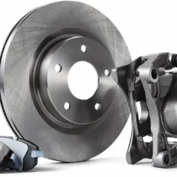 Nowe, metalowe tarcze hamulcowe, klocki i zacisk na białym tle, gotowe do montażu.