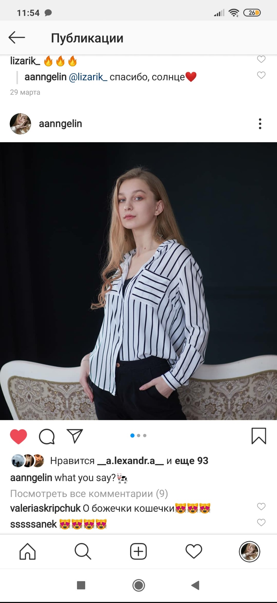 Portret młodej kobiety z blond włosami w czarno-białej koszuli w paski, pozującej na tle ciemnego tła i ozdobnego fotela.