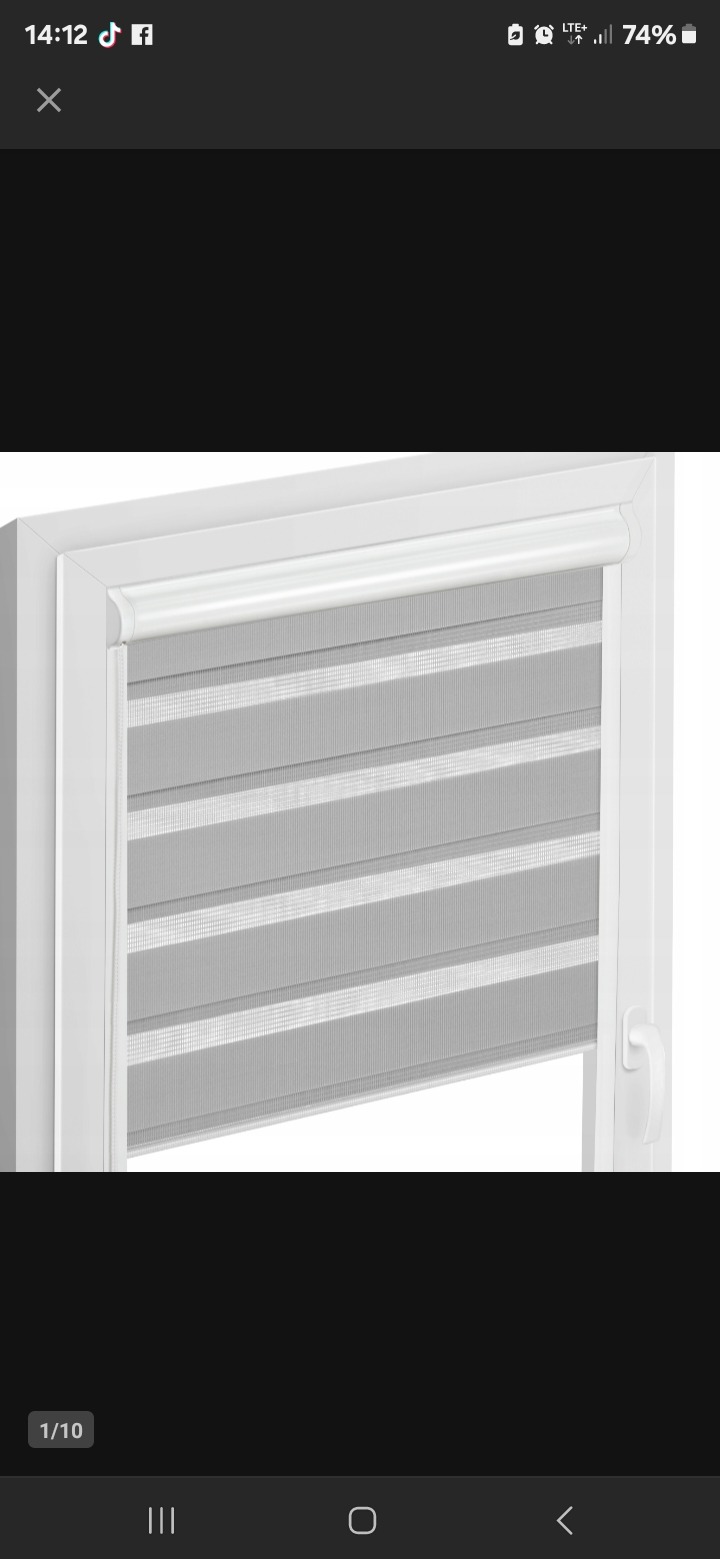 Szara roleta dzień noc w białej ramie okiennej, widoczna z bliska. Poziome pasy tkaniny naprzemiennie zaciemniają i przepuszczają światło. Minimalistyczny design.