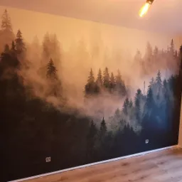 Pokój po odświeżeniu z fototapetą przedstawiającą mglisty las, zamontowaną na całej ścianie, widoczne gniazdka elektryczne, drewniana podłoga i fragment szafy w zabudowie po lewej stronie, żarówki...