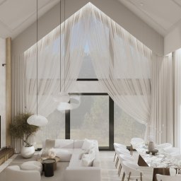 Eco Klima Mateusz Lipiński - Jasne, przestronne wnętrze z wysokim sufitem i dużym oknem, z nowoczesnym białym narożnikiem i marmurowym stołem jadalnym. Delikatne zasłony i minimalistyczne lampy.