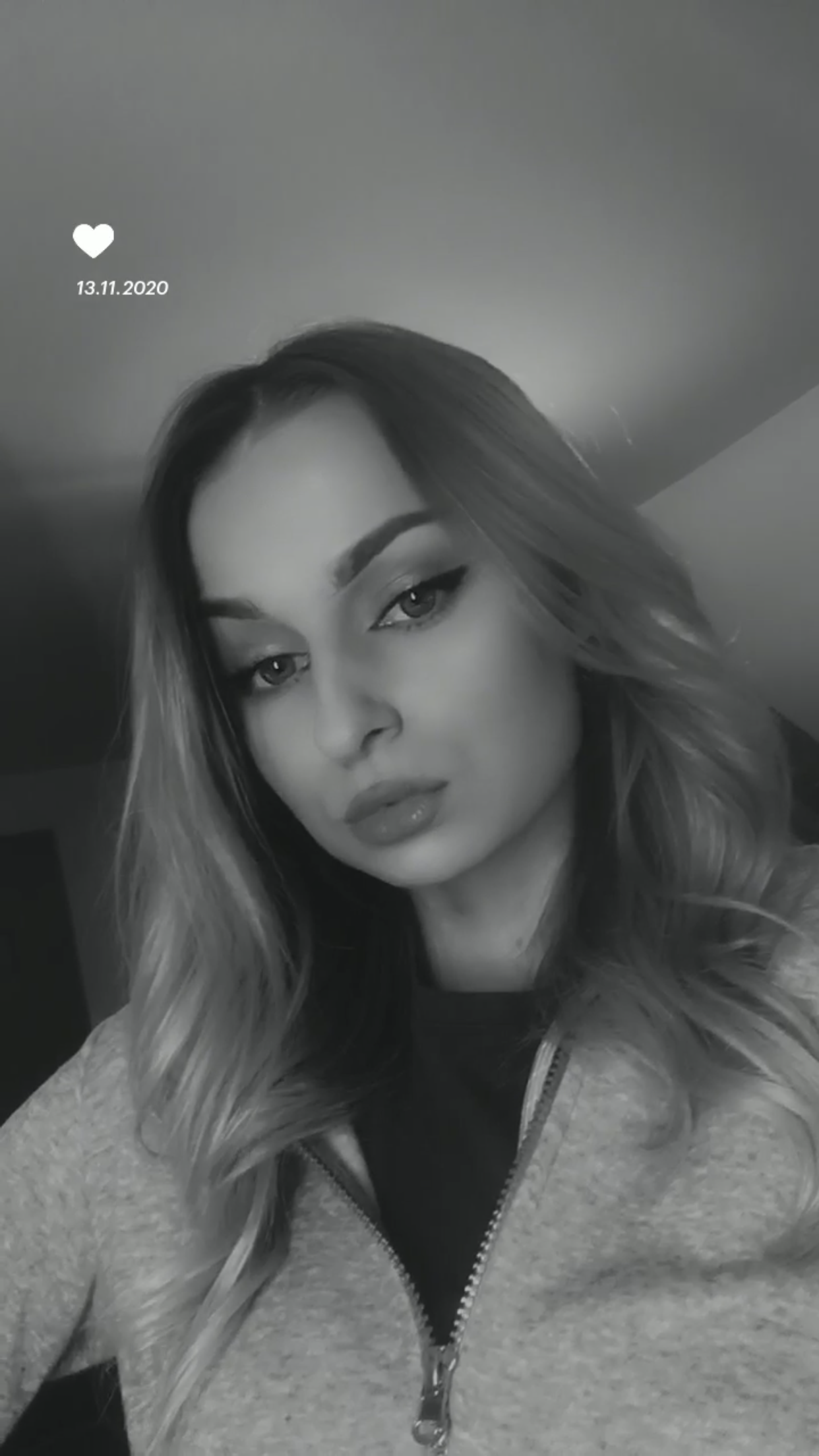Czarno-białe zbliżenie na twarz młodej kobiety z mocnym makijażem oczu i ust, skierowana lekko w dół, z datą 13.11.2020 i ikoną serca w lewym górnym rogu.
