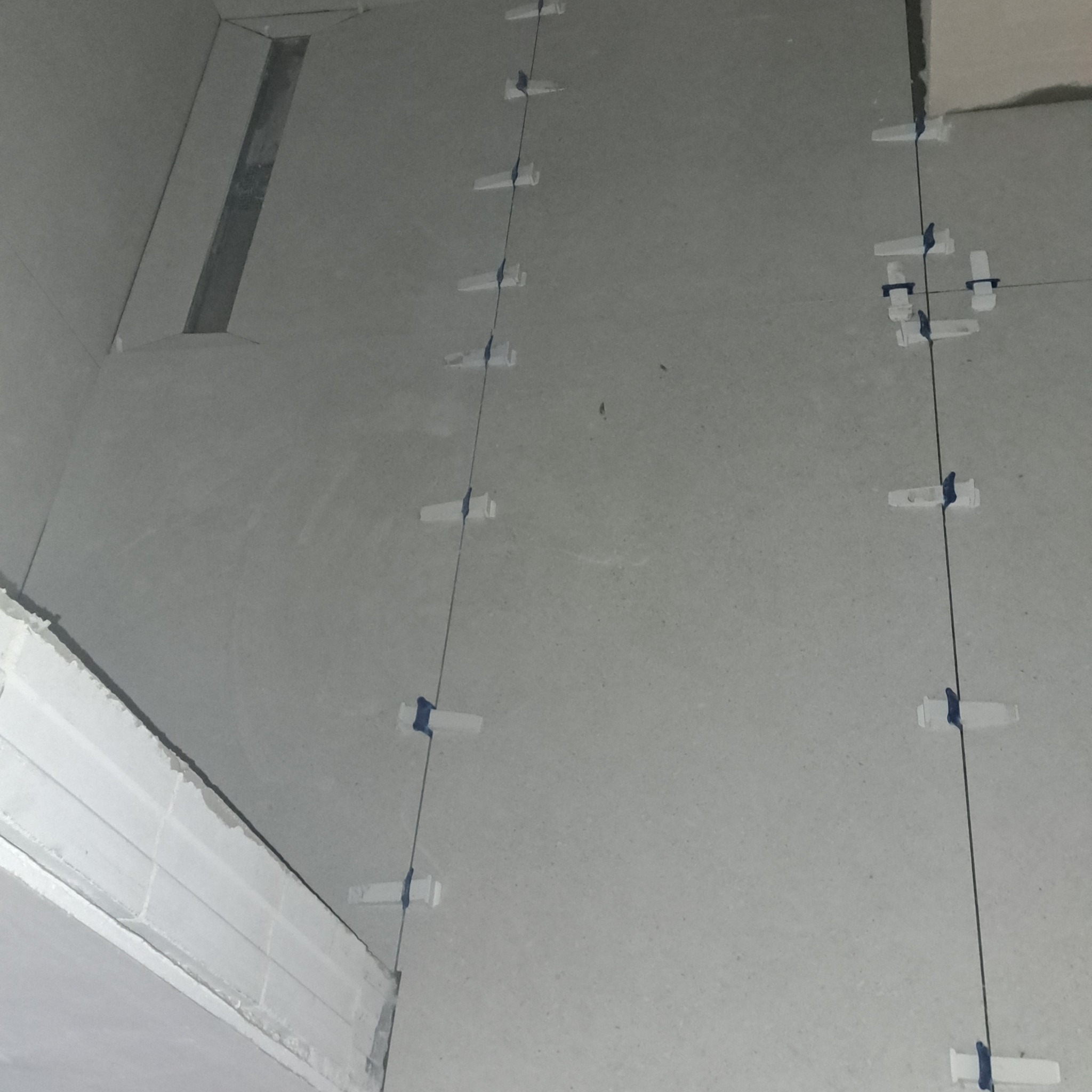 Przygotowanie do układania płytek w łazience w Godziszewie, widoczne listwy i system poziomowania płytek.