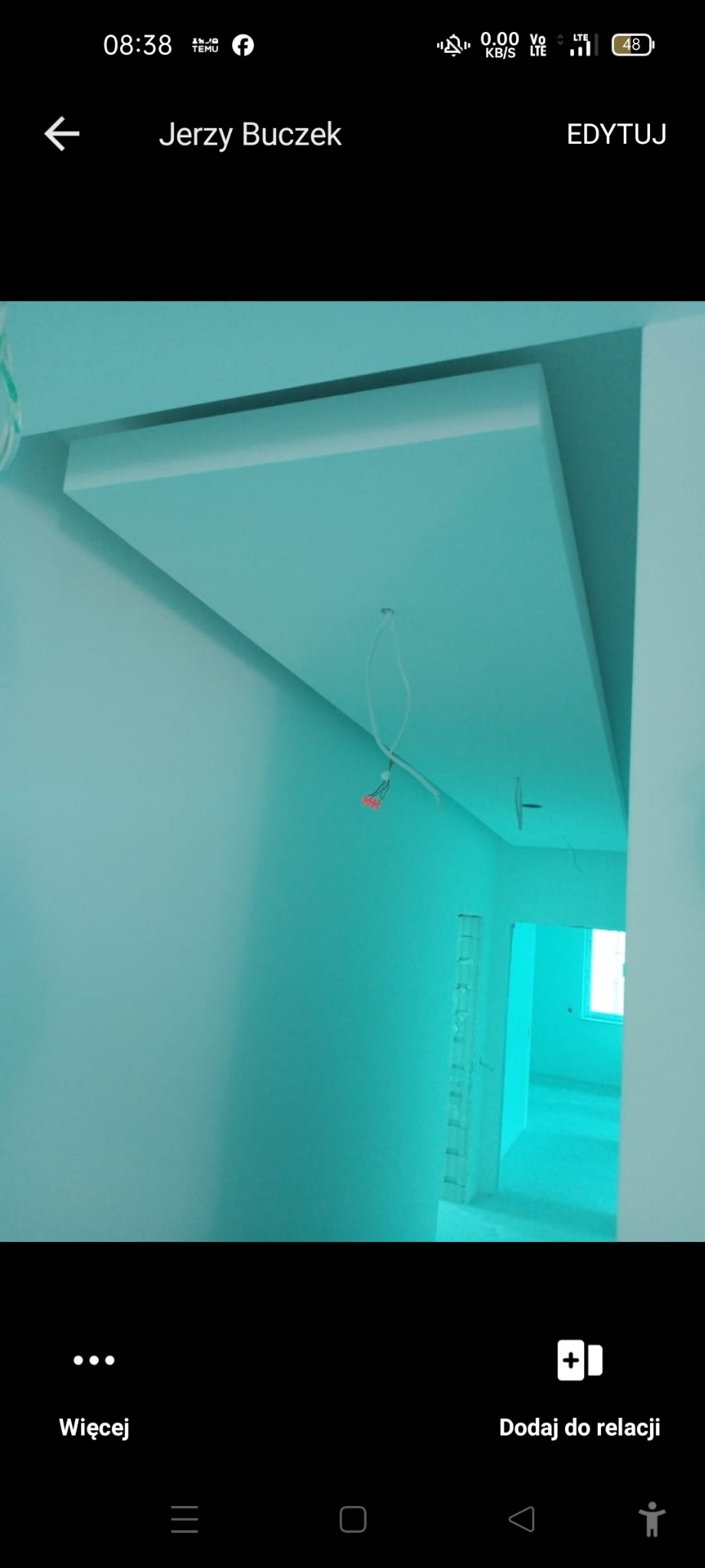 Wykończony sufit podwieszany z płyty gipsowej w świeżo pomalowanym na turkusowo wnętrzu. Widoczne kable i fragment ściany z otwartym przejściem.