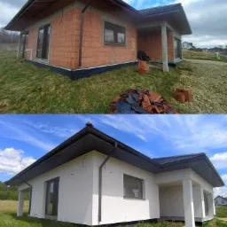 Porównanie stanu surowego i wykończonego domu jednorodzinnego z płaskim dachem, widoczne zmiany w elewacji od czerwonej cegły do białego tynku, z stertą potłuczonych dachówek przed budynkiem.