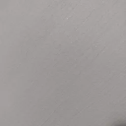 Szara ściana z delikatną, poziomą fakturą, nierównomiernie oświetlona, ukazująca subtelne cieniowanie.