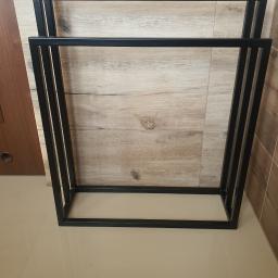 Metaldecor S&G - Stojak na ręczniki z czarnego metalu, spawany, widok z góry na jasnych płytkach podłogowych i ścianie z imitacją drewna.