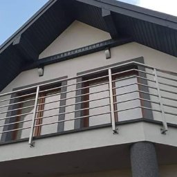 Spaw LOFT - Elegancka, pozioma konstrukcja zabezpieczająca balkon na piętrze domu z jasną elewacją i ciemnym dachem, widok od dołu.