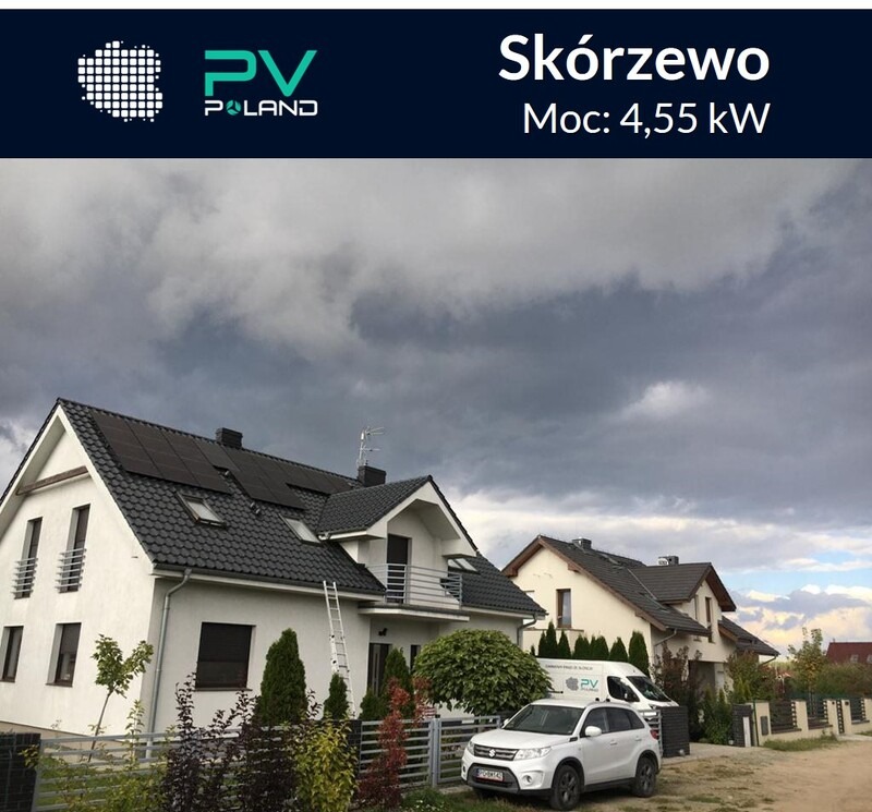 Instalacja paneli słonecznych na dachu białego domu jednorodzinnego w Skórzewie, moc 4,55kW, pochmurne niebo, drabina oparta o ścianę, samochód firmy na podjeździe.