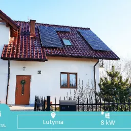 Instalacja paneli słonecznych na dachu domu jednorodzinnego w Częstochowie z czerwoną dachówką, widok z poziomu ogrodu.