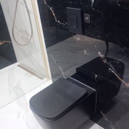 Kris-Rem Remont i Wykończenia wnętrz - Nowoczesna, czarno-biała łazienka z wiszącą toaletą o matowym wykończeniu, kabiną prysznicową ze złotymi akcentami i marmurowymi płytkami na ścianach i podłodze.