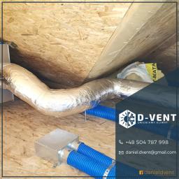 D-VENT Daniel Prusiński - Instalacja przewodów wentylacyjnych w przestrzeni poddasza, widoczne srebrne, izolowane rury i niebieskie, karbowane przewody doprowadzające powietrze do centrali wentylacyjnej, zamontowanej...