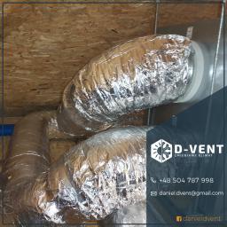 D-VENT Daniel Prusiński - Elastyczne, izolowane przewody wentylacyjne pod stropem z desek, połączone z metalową skrzynką rozdzielczą, widoczny fragment niebieskiej rury.