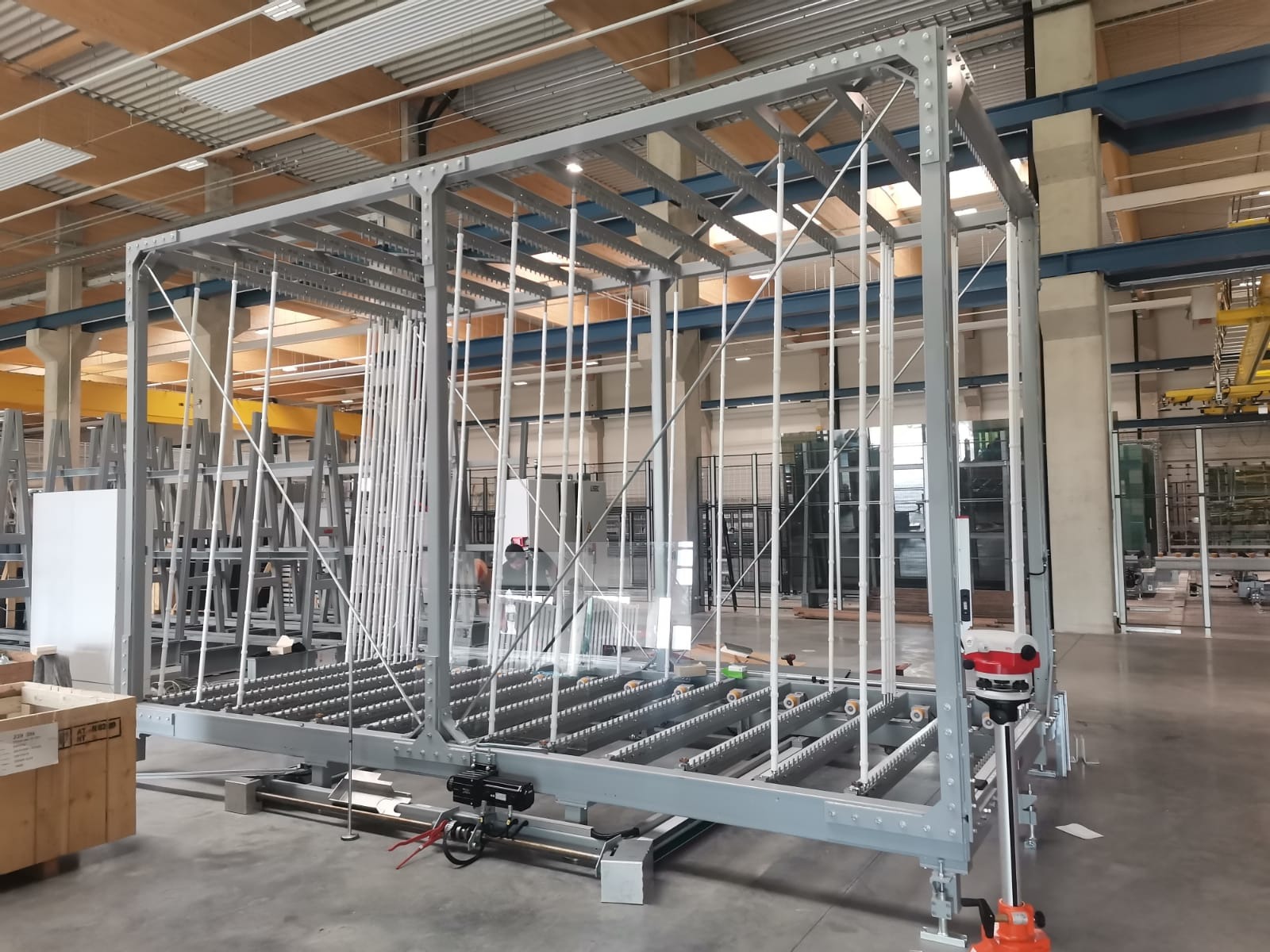 Stalowa konstrukcja hali produkcyjnej w Wąwelnie z elementami transportu wewnętrznego, widoczne rolki i pionowe podpory.