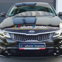 Czarny samoch&oacute;d Kia Optima z logo Futuro Finanse na masce i tablicy rejestracyjnej, prezentowany z przodu na tle szarej bramy garażowej.