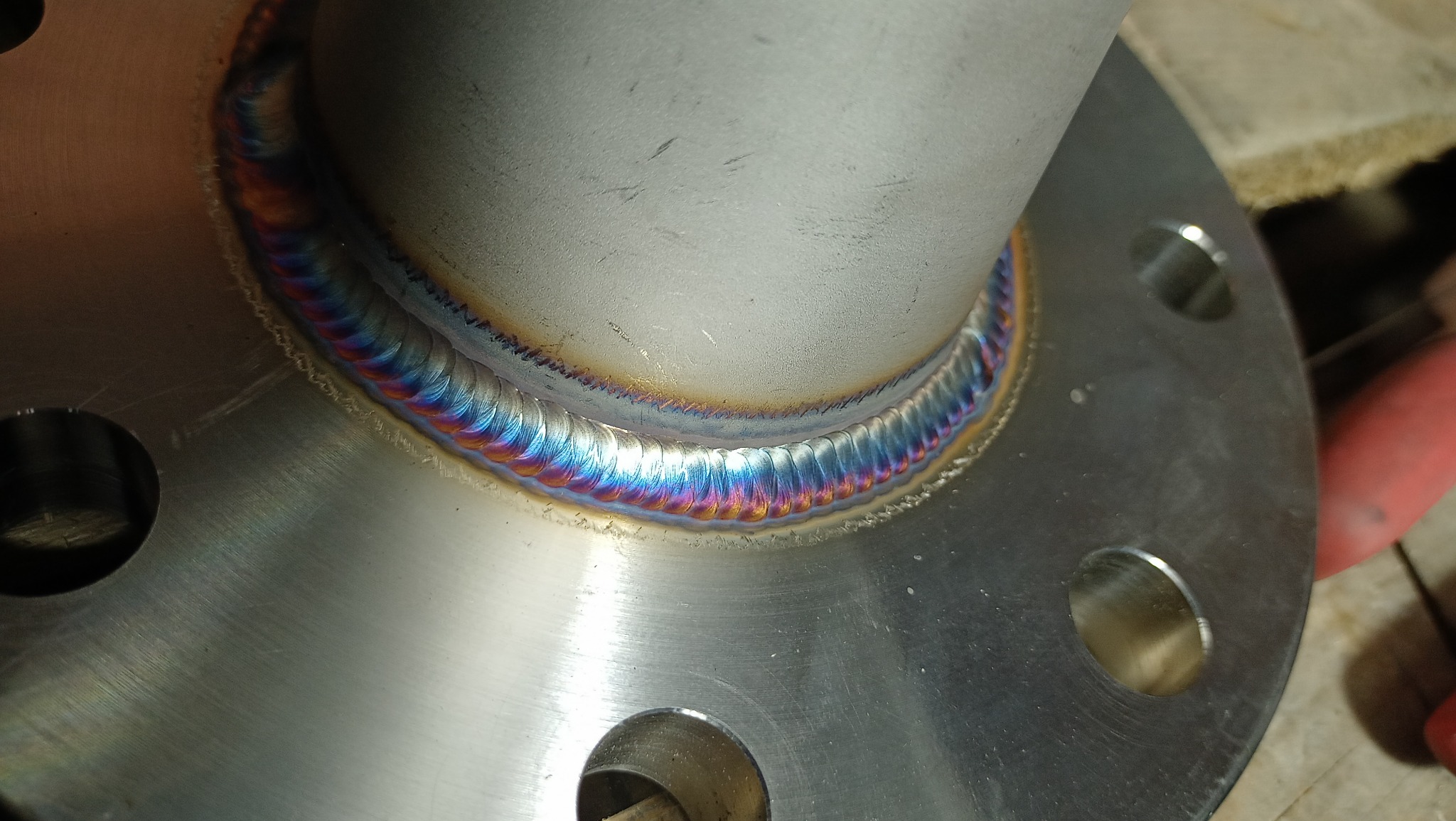 Spoina pierścieniowa rury ze stalową flanszą, wykonana w Leśnej Podlaskiej, z widocznymi kolorami hartowania.