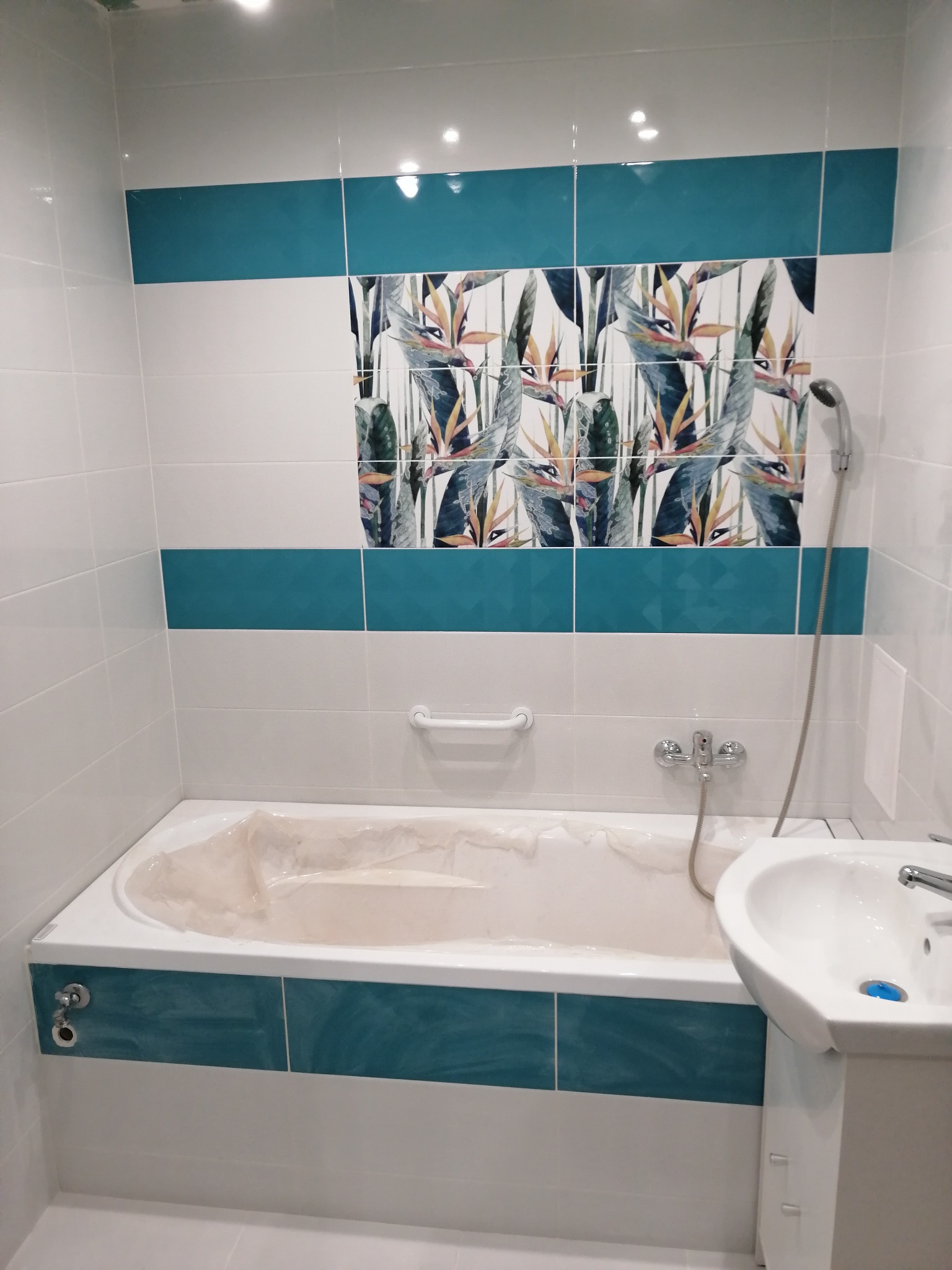 Ułożenie płytek na ścianie wraz z montażem wanny i oświetlenia LED na suficie