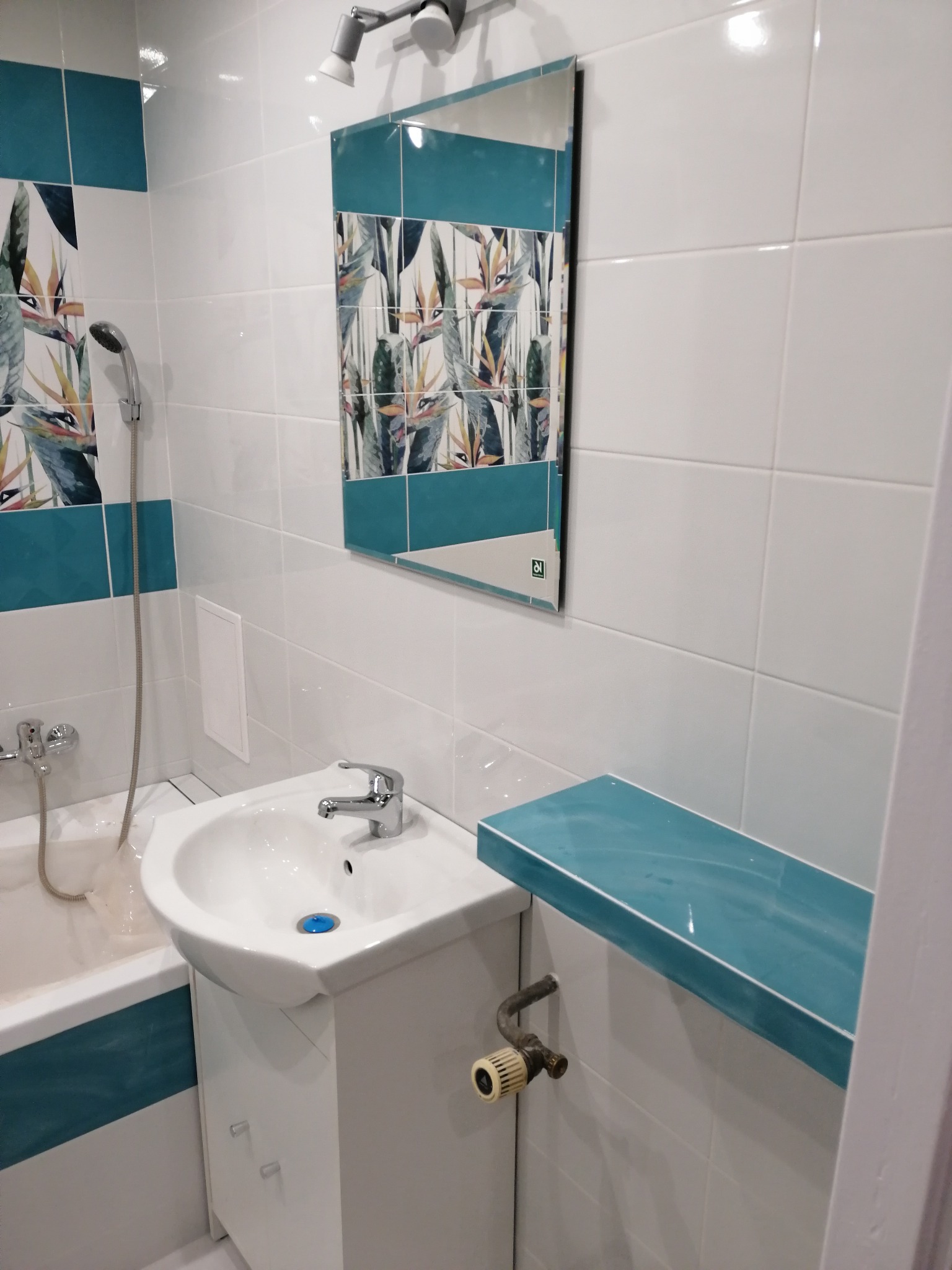 Ułożenie płytek na ścianie wraz z montażem zlewu i lustra