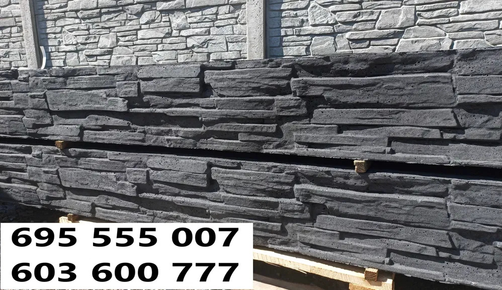 Ciemnoszare panele imitujące kamień, ułożone jeden na drugim, tworzące element ogrodzenia betonowego. W tle widoczny fragment ogrodzenia z jasnoszarego kamienia.