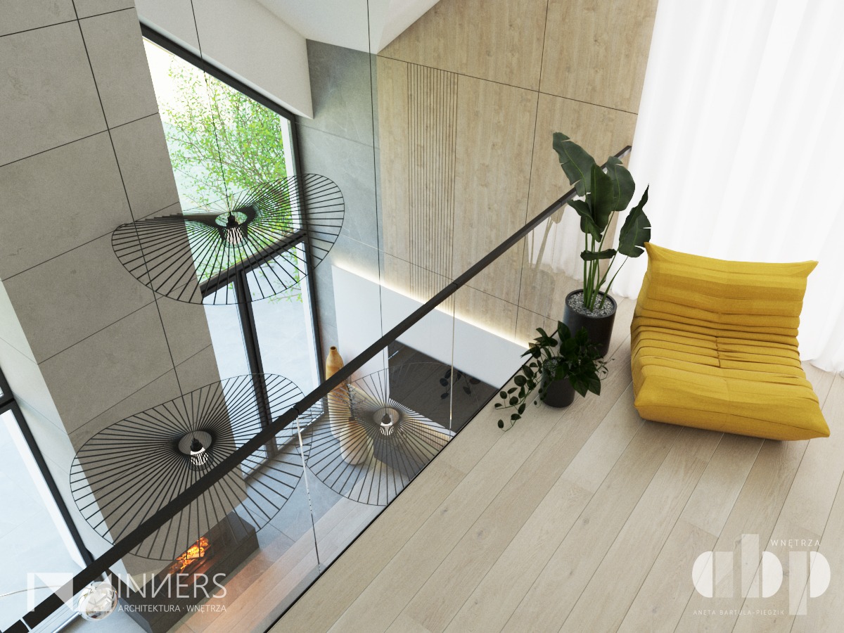 Nowoczesne wnętrze z widokiem z góry: minimalistyczne lampy wiszące, szklana balustrada, drewniana podłoga, żółty fotel puf i rośliny doniczkowe.