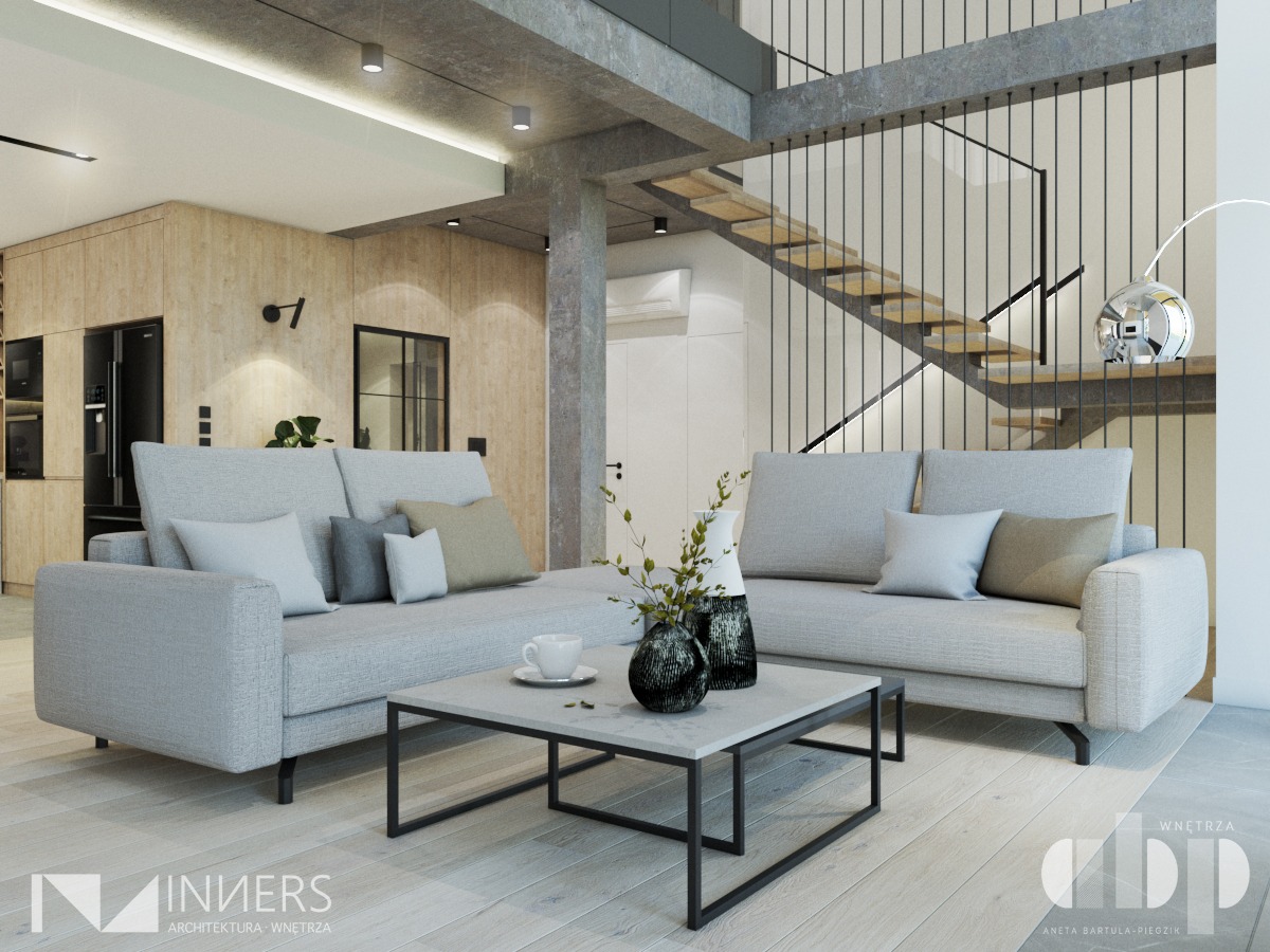 Jasne wnętrze salonu z dwoma szarymi sofami, marmurowym stolikiem kawowym, drewnianą podłogą i schodami z metalową balustradą w tle.