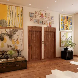 Jasne, przestronne wnętrze z drewnianą podłogą, ozdobione obrazami, roślinami w donicach i dekoracyjnymi elementami, w tym skrzynią i stolikiem, oświetlone naturalnym światłem wpadającym przez okno...