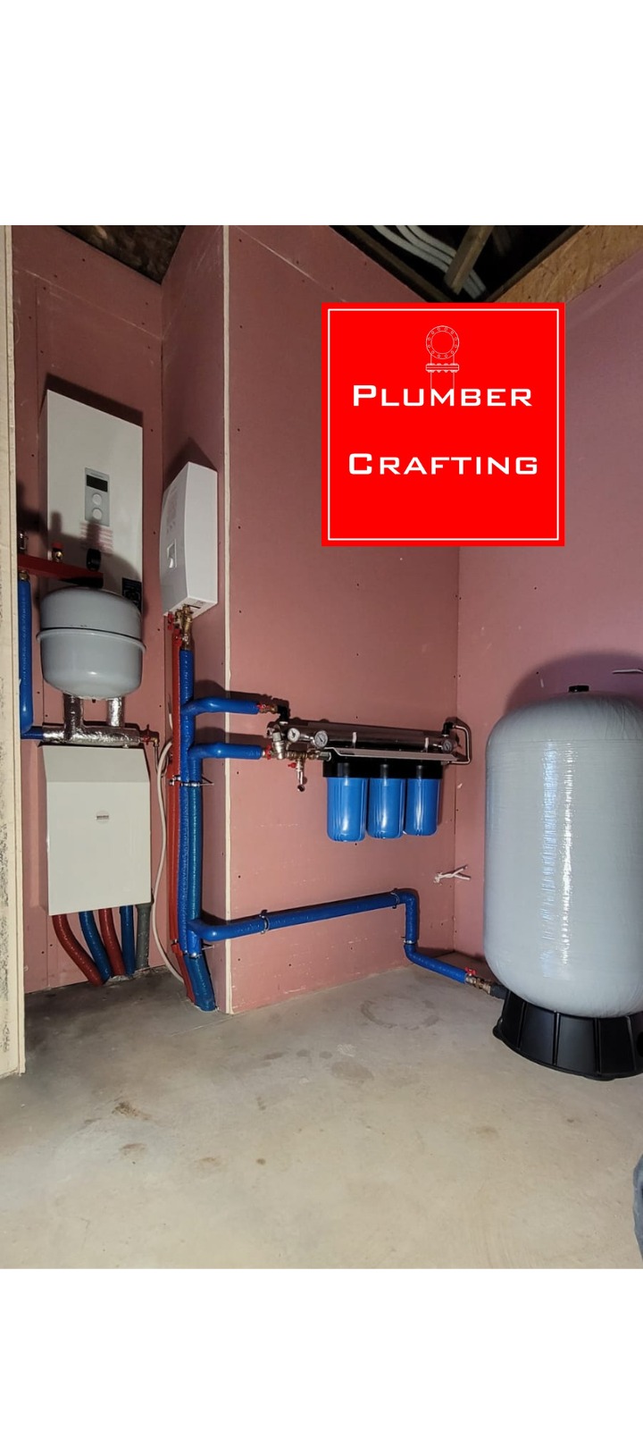 Złożona instalacja wodna z niebieskimi rurami, filtrami i zbiornikiem ciśnieniowym na tle surowej ściany. Widoczny piec i dodatkowe elementy instalacji.