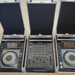 Profesjonalny sprzęt DJ Pioneer: dwa odtwarzacze CDJ-2000 Nexus i mikser DJM-900 Nexus w aluminiowych skrzyniach transportowych z piankowym wnętrzem.