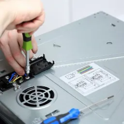 Podłączenie przewodów do płyty indukcyjnej od spodu, widoczne schematy połączeń i narzędzia.