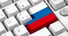 Klawiatura komputera z jednym klawiszem pomalowanym w barwy flagi Rosji, widok z góry pod kątem.