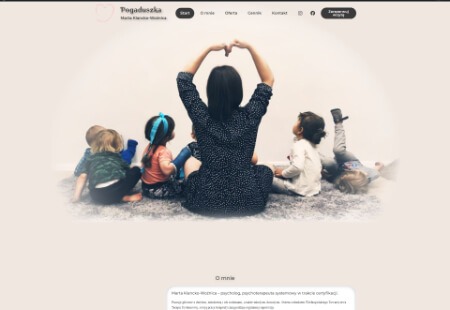 Strona internetowa z wizerunkiem kobiety siedzącej po turecku z dziećmi, tworzącej dłońmi kształt serca, w tle jasna ściana i dywan.