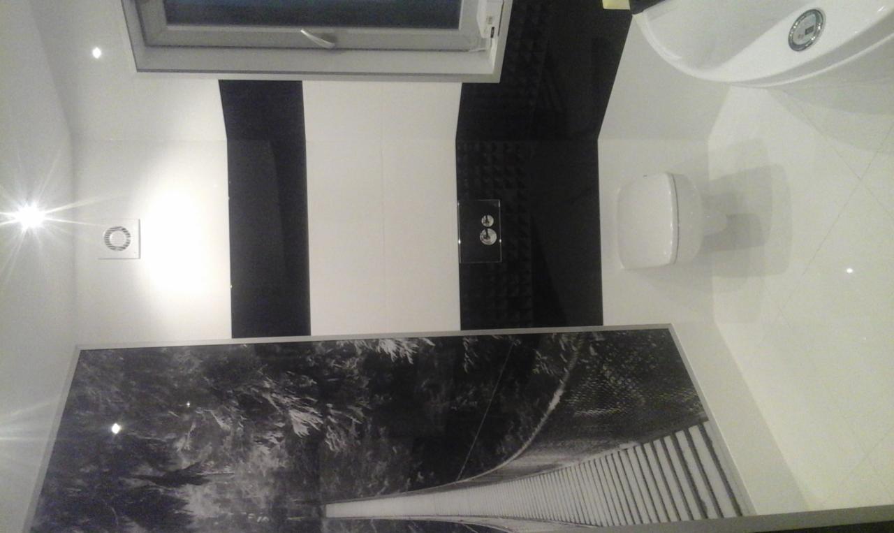 Nowoczesna łazienka z białymi płytkami, czarnymi akcentami i fototapetą z motywem mostu, widok z góry.