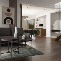 Nowoczesny salon z szarą sofą narożną, okrągłymi stolikami kawowymi, drewnianą podłogą i schodami z czarnymi balustradami, widok na jadalnię z zielonymi krzesłami.