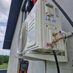 INSTALMATE Mateusz Ząbek - Kremowy klimatyzator Rotenso Imoto zamontowany na elewacji domu, z podłączonym miernikiem Testo 552 wskazującym 4800. Widoczne przewody i elementy instalacji.